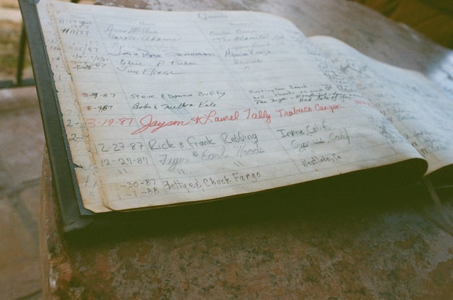 An open house guest book with a handwritten entry reading Tiger & Earl Woods.