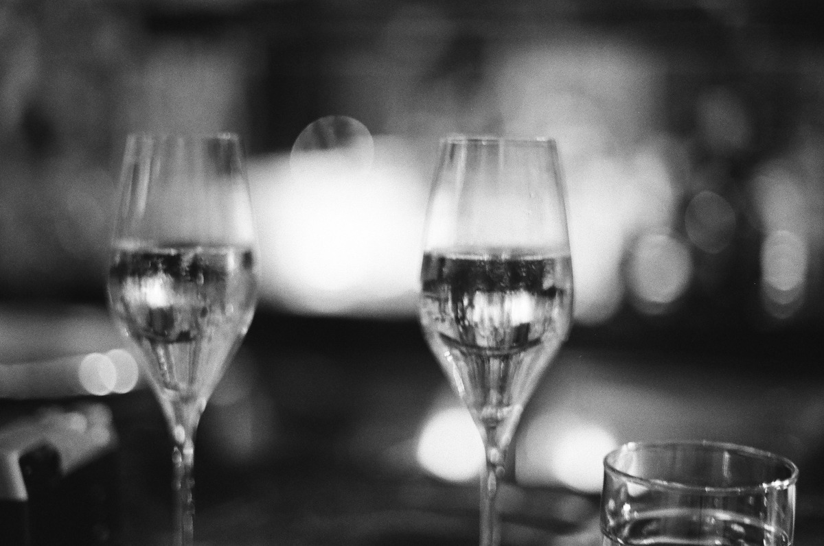 Two glasses on a table in a softly focused black-and-white photograph