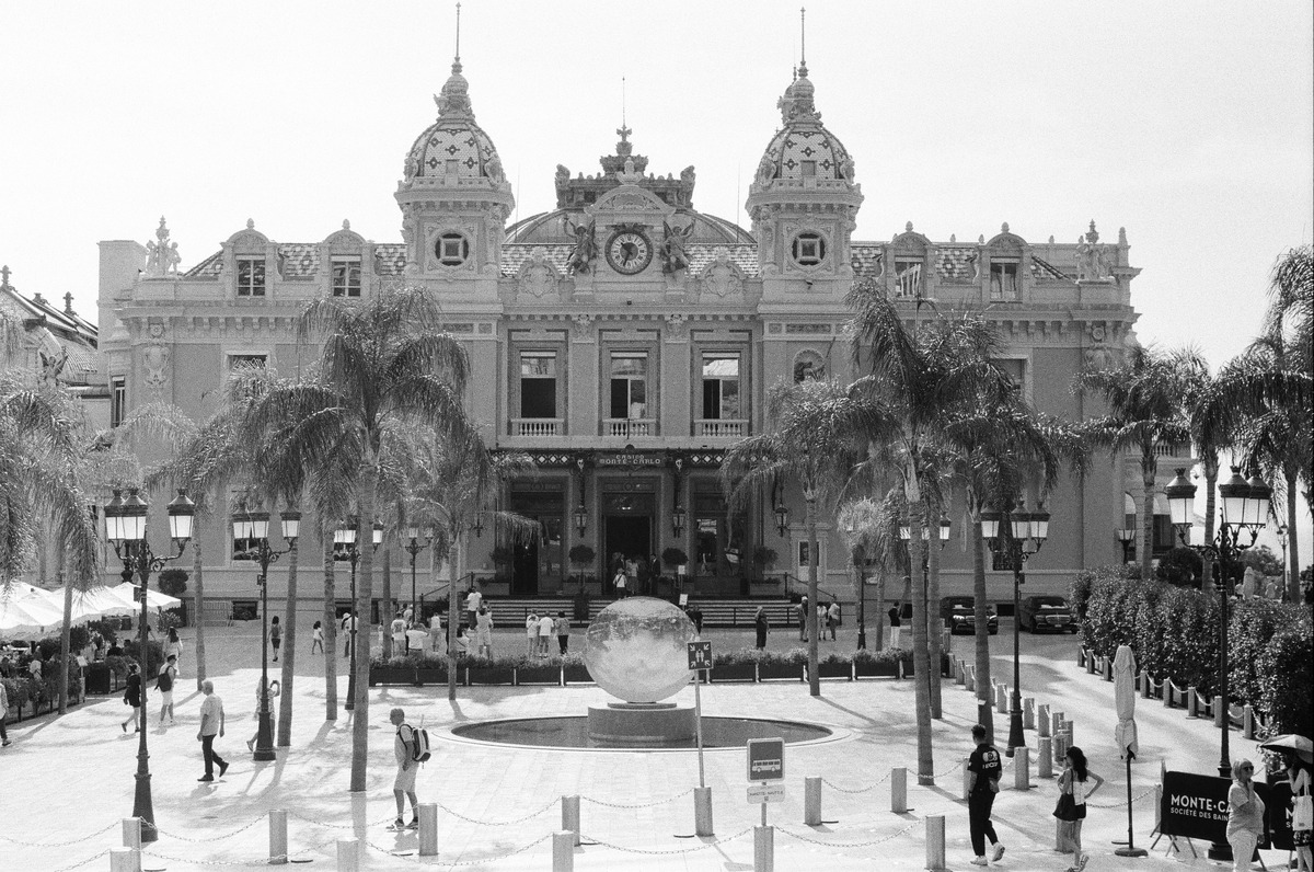 A black-and-white photograph of the Casino Monte-Carlo facade and square