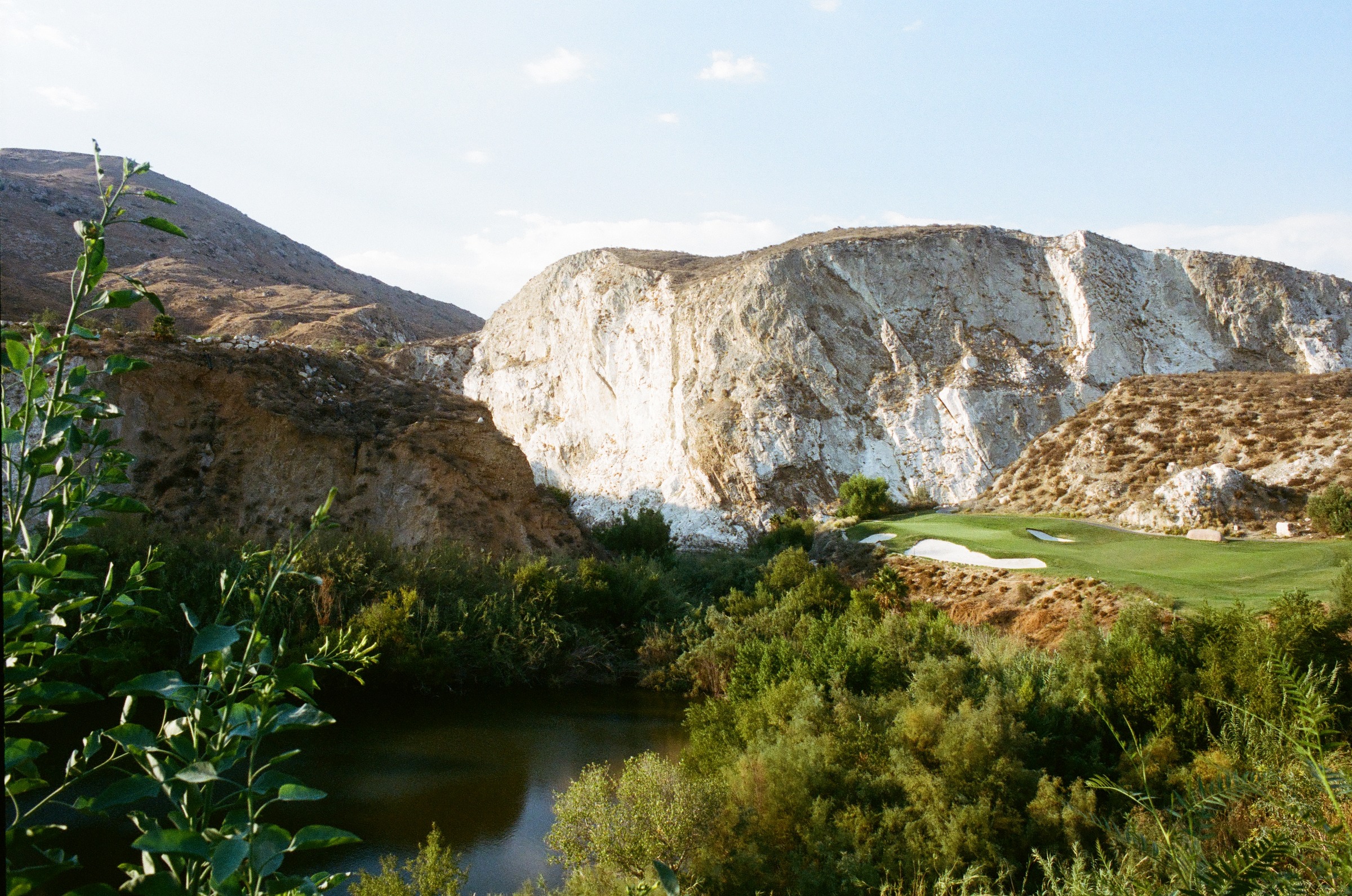 A green and white bunkers beneath the quarry wall at Oak Quarry